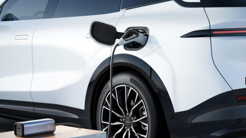 White EV plugged into a CCS2 charger demonstrating two-way charging capability.